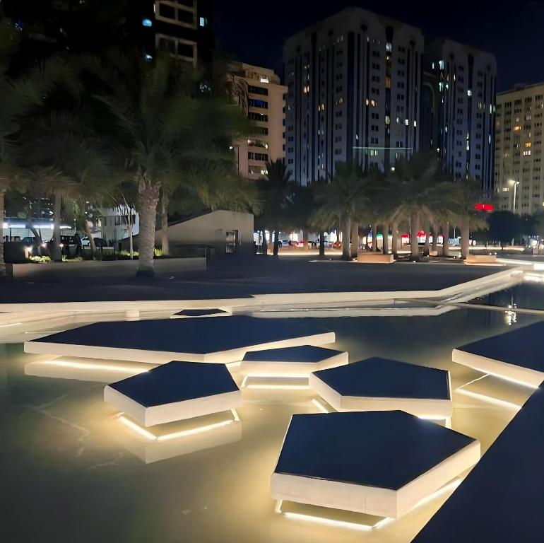 Heart of Abu Dhabi - Pearl Room في أبوظبي: مسبح مع انارة في مدينة في الليل