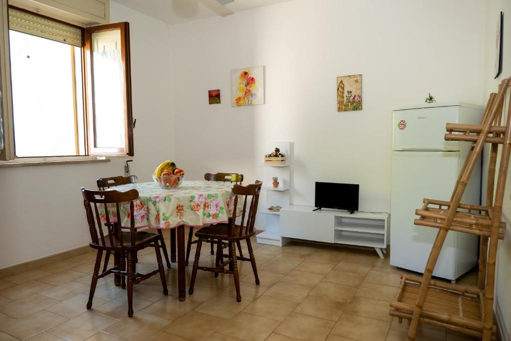 uma cozinha com uma mesa e cadeiras e um frigorífico em A casa di Franco e Rosa em Leuca