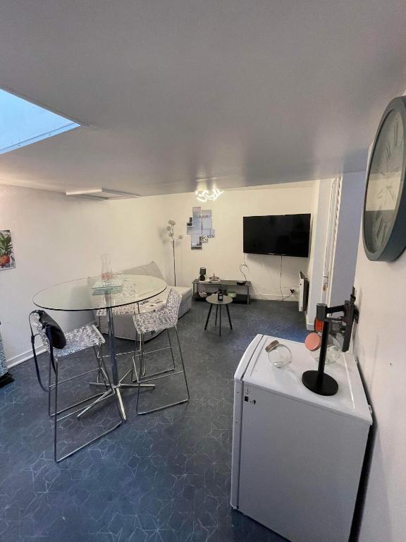 een woonkamer met een tafel en stoelen en een televisie bij Joli petit F1 plein centre ville in Eu