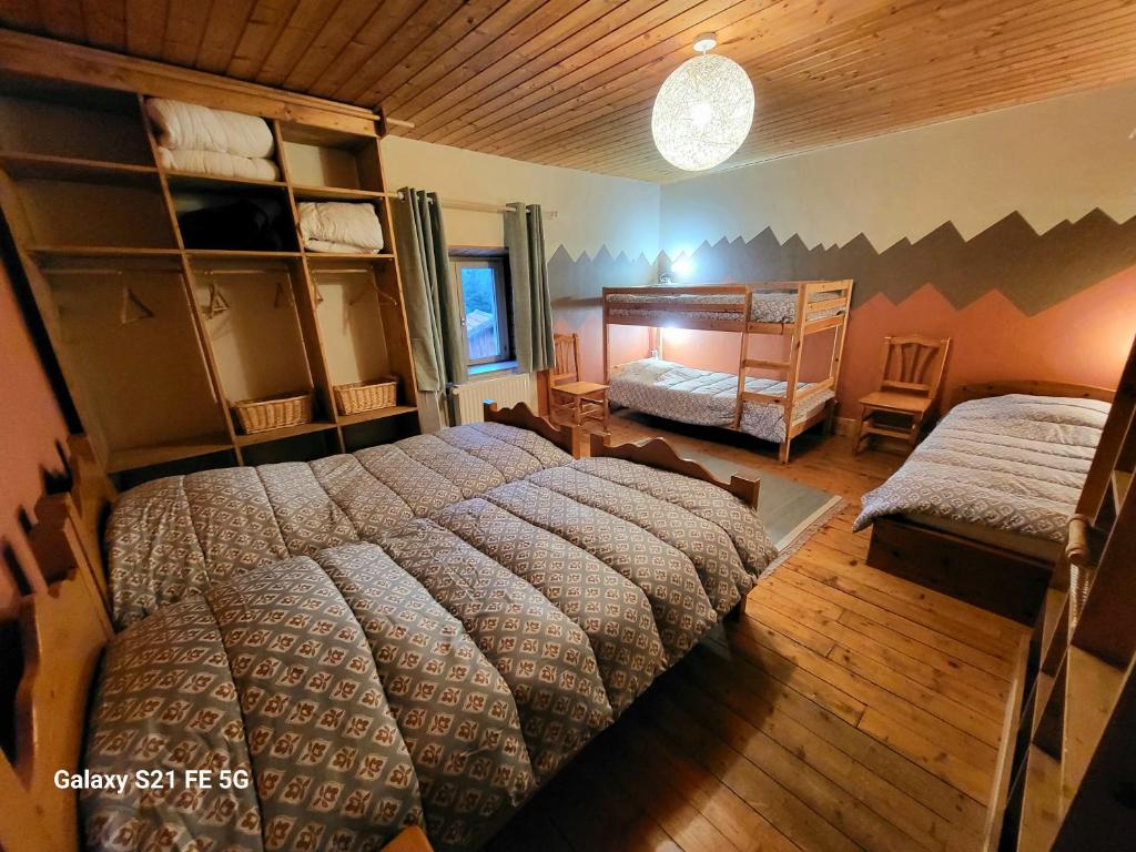 een slaapkamer met een groot bed en een stapelbed bij Gîte du Grand Cher in Les Rousses