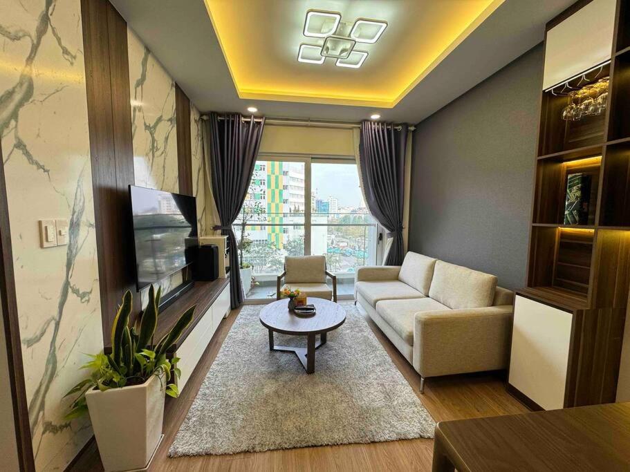 - un salon avec un canapé et une télévision dans l'établissement Happy House, à Hạ Long