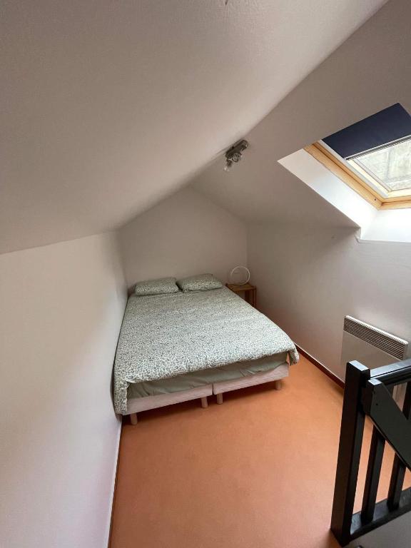 ein kleines Schlafzimmer mit einem Bett im Dachgeschoss in der Unterkunft Joli petit F1 plein centre ville in Eu