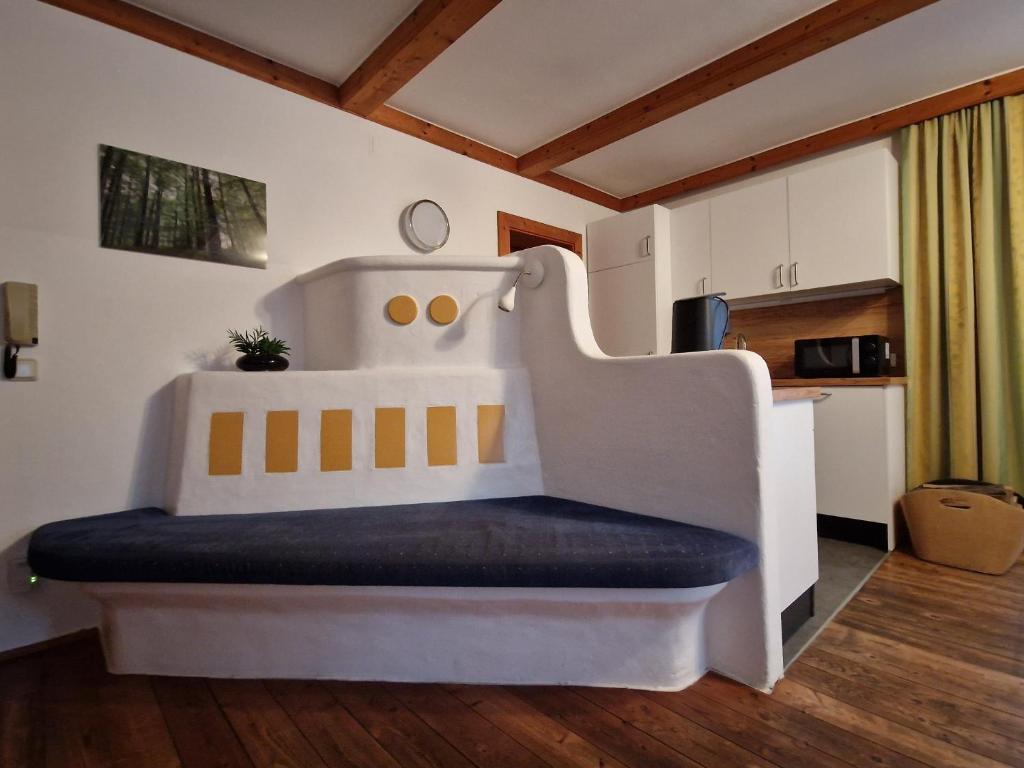 uma grande cama branca com um banco num quarto em Kachelofenwohnung Pölzleitner em Annaberg im Lammertal