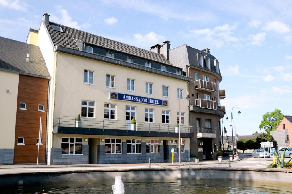 a building next to a body of water at Ambassador Hotel Eupen in Eupen