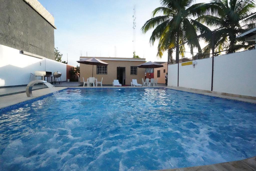 uma grande piscina com água azul em Villa Sol Taino, Hotel en Boca chica, 5 minutos del Aeropuerto Internacional las Américas em La Golondrina