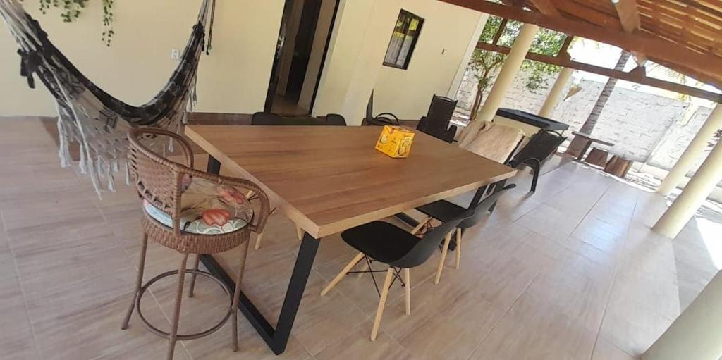 Chalé Brisas do Rio في بترولينا: طاولة وكراسي خشبية في غرفة مع أرجوحة