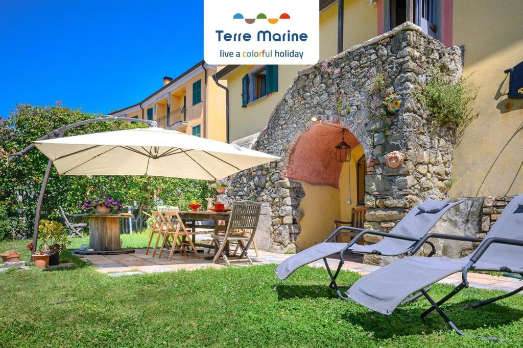 une terrasse avec une table, des chaises et un parasol dans l'établissement L'Occhio di Santa Lucia, Terre Marine, à La Spezia