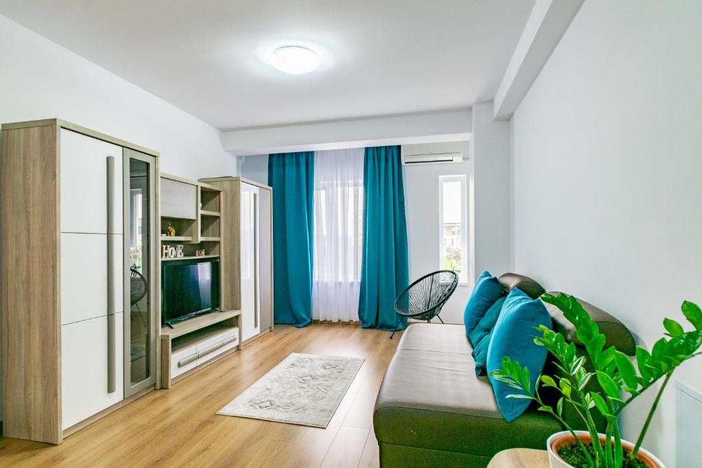 a living room with a green couch and a tv at Apartament Central in Craiova