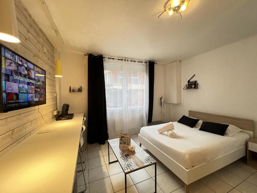 une chambre avec un lit blanc et une télévision dans l'établissement Le Worker 1, à Calais