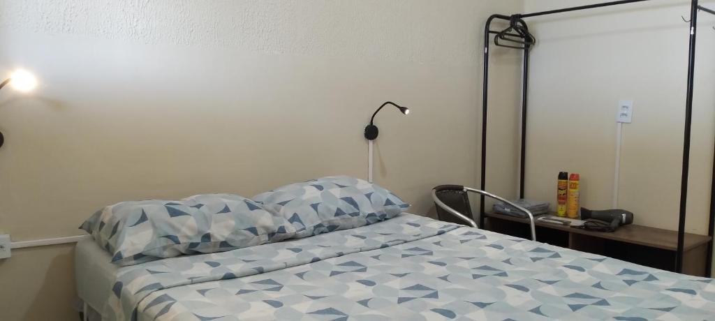um quarto com uma cama e uma secretária com um candeeiro em Kitnet Marília em Marília