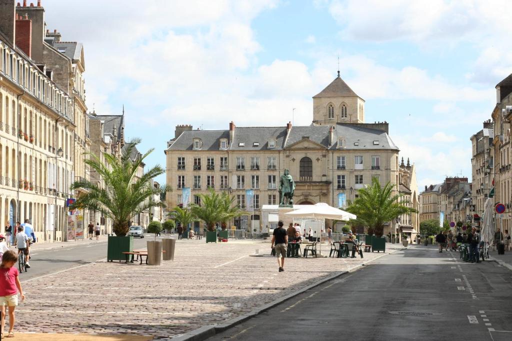 a city street with a large building in the background at Le Castel d&#39;Orne - Piscine et Terrasse in Caen