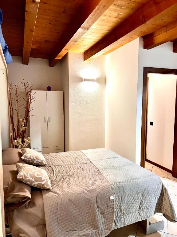 ein Schlafzimmer mit einem großen Bett und einer Holzdecke in der Unterkunft Alloggi Mincio in Goito