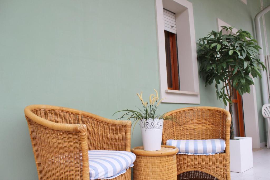 グラードにあるAppartamenti Rosannaの植物の置かれたポーチに座る籐椅子2脚