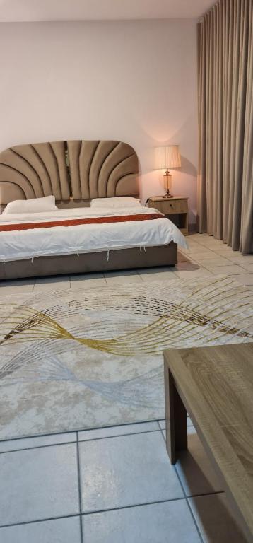 a bedroom with a large bed and a table at فيلا بيتا خصوصيه في الشاطئ والمسبح in Durat  Alarous