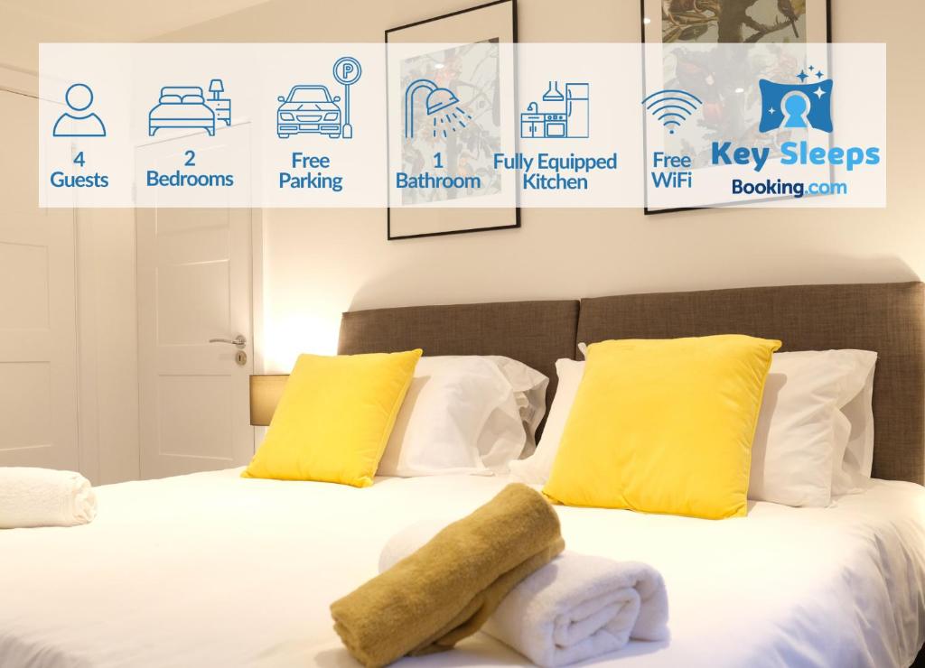 a bedroom with a bed with yellow pillows and logos at Modern Two Bedroom By Keysleeps Short Lets Northampton With Free Parking Garden Contractor Leisure 