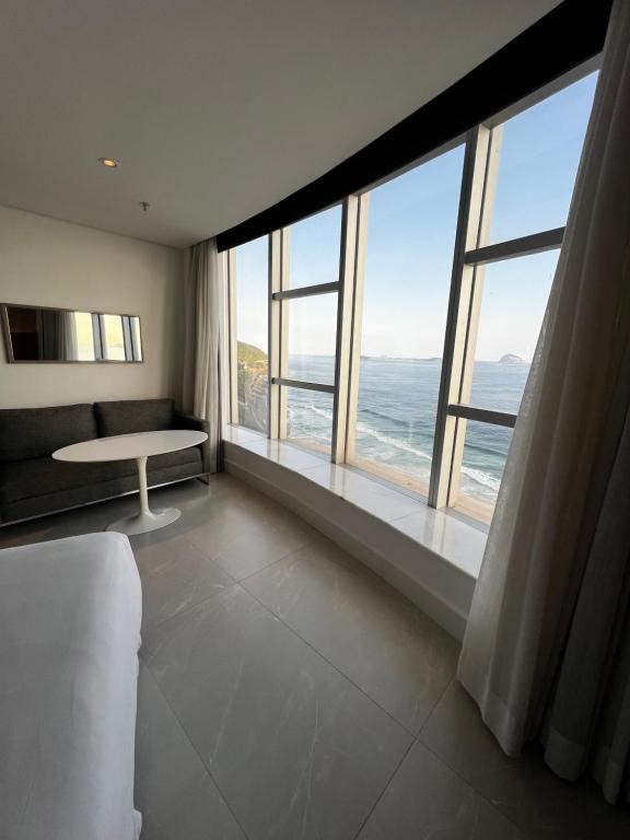 a room with a large window with a view of the ocean at Hotel Nacional in Rio de Janeiro