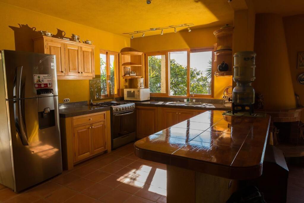 a kitchen with a stainless steel refrigerator and cabinets at Casa Maria Vista, Espectacular View in Santa Cruz La Laguna