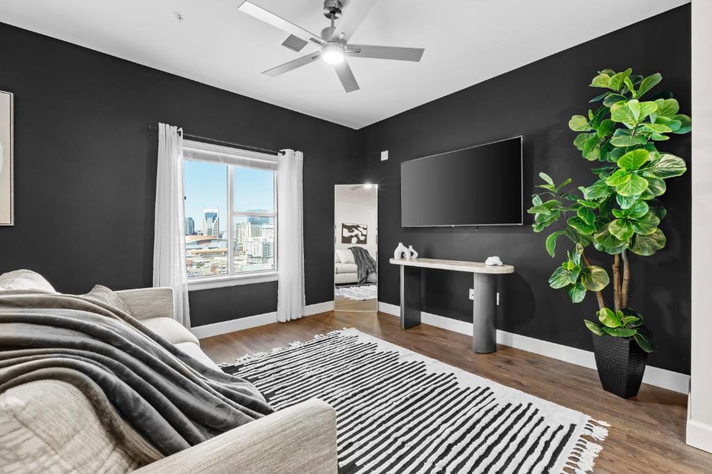 een woonkamer met een bank en een tv bij Midnight Manor Penthouse Suite The Gulch in Nashville