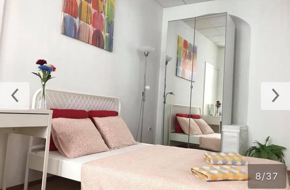 a bedroom with a bed with pink pillows and a mirror at FlatMetro Rooms in Budapest