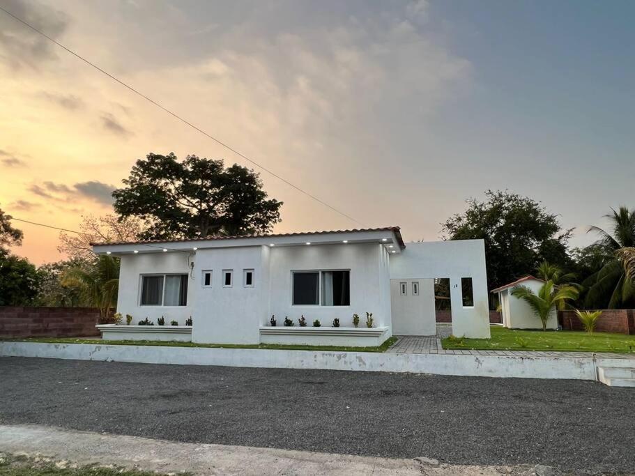 a white house sitting on the side of a street at Villa Callarí in El Zapote