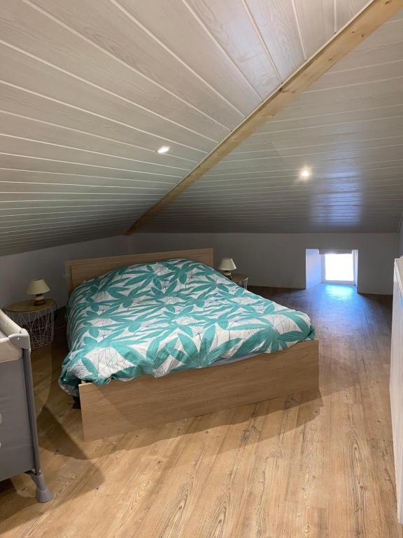 a bedroom with a bed in a attic at Petite maison au cœur de l Auvergne in Jumeaux