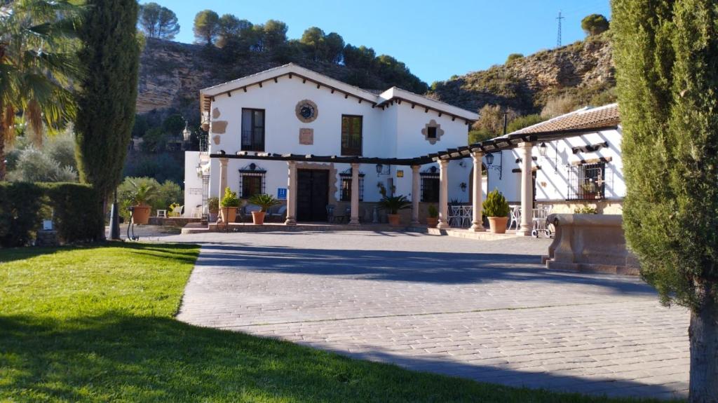 una casa blanca con una palmera en Hotel La Hoya del Tajo en Ronda