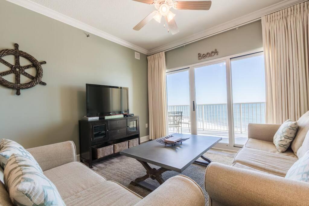 a living room with two couches and a flat screen tv at Seawind By Liquid Life in Gulf Shores