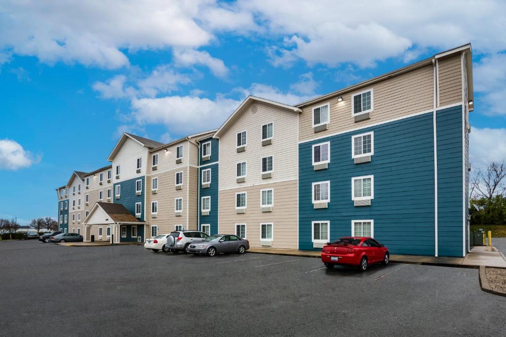 a large apartment building with cars parked in a parking lot at WoodSpring Suites Lexington Southeast in Lexington