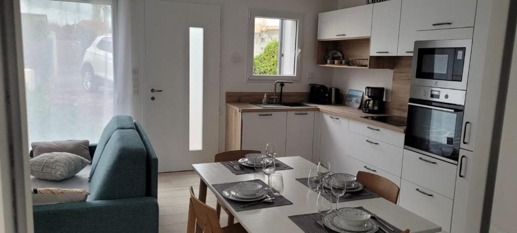uma cozinha com uma mesa e uma cadeira azul num quarto em New house on the seafront em Hermanville-sur-Mer