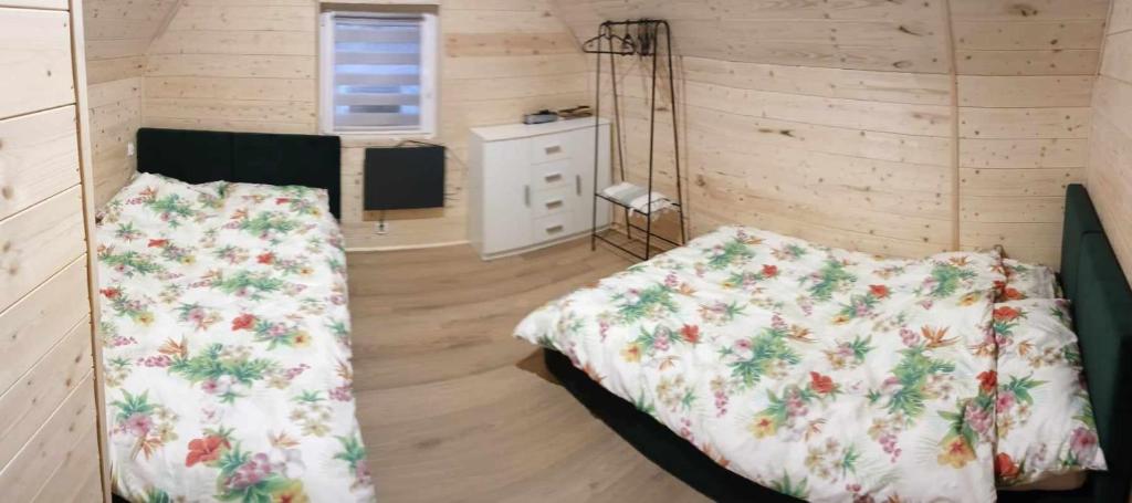 a bedroom with two beds and a television in it at Nadmorska Sarbinowo in Sarbinowo
