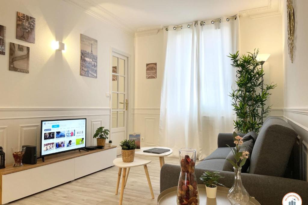 un salon avec un canapé et une télévision dans l'établissement Le Palais des Glaces - Hypercentre - Port, à Caen