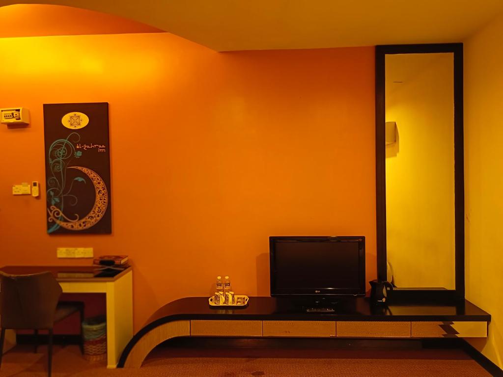 a room with a television on a table with a mirror at Hotel Zara in Sungai Petani