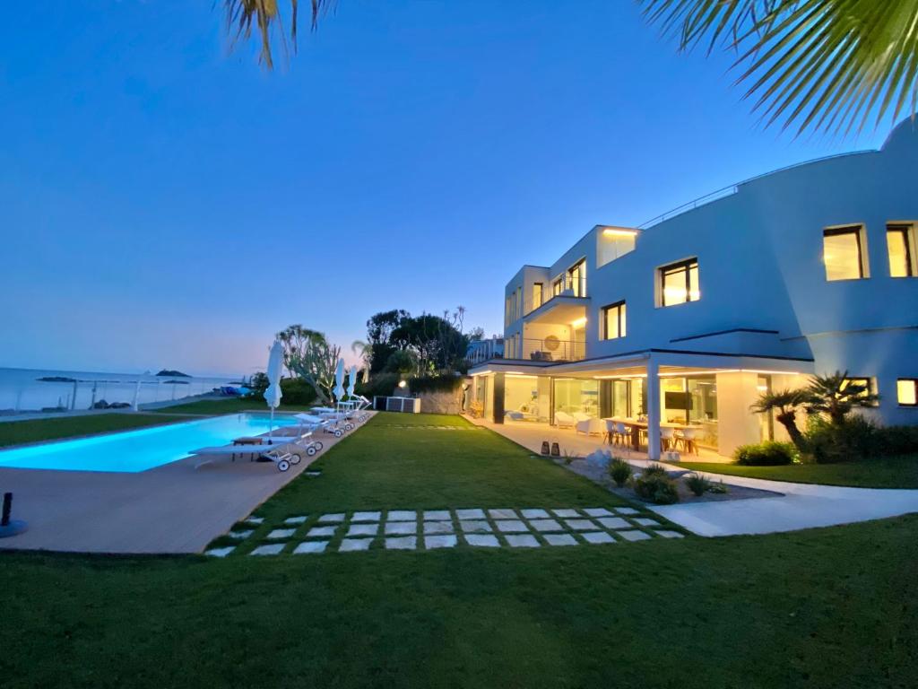 una grande casa con piscina di notte di Fenandgi Luxury Hospitality at its finest ! a Porto Columbu - Perdʼe Sali