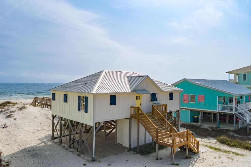 a house on the beach next to the ocean at Flip Flops & Sun in Gulf Shores