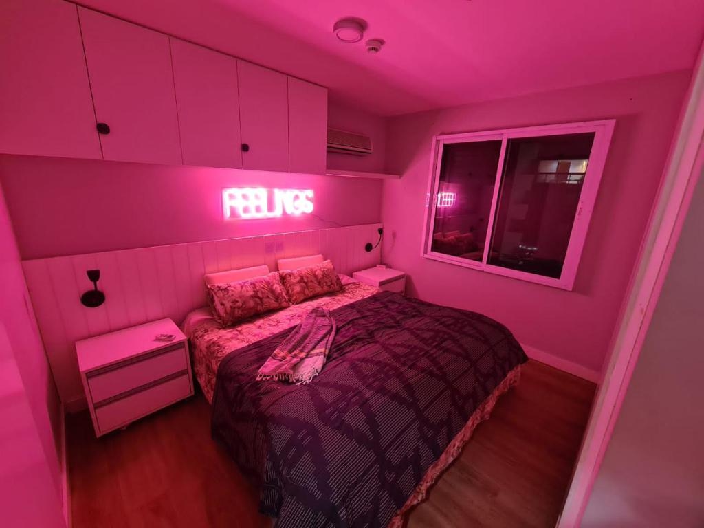 a pink bedroom with a bed and a neon sign at Flat Hotel Mercure - 4 Estrelas Moema SP in Sao Paulo