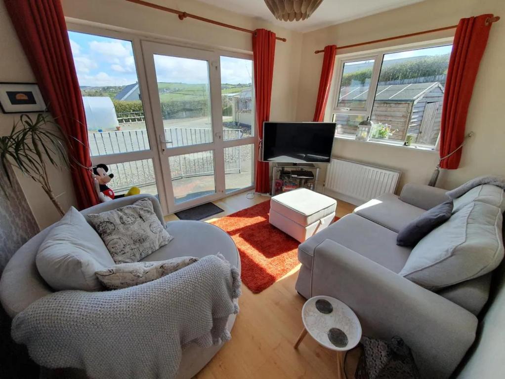 a living room with two couches and a television at Quiet 2-Bedroom Buncrana Home in Buncrana