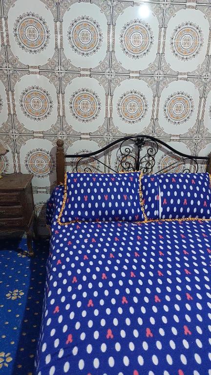 a blue bed with polka dot sheets in a bedroom at Maison d'hôtes grand atlas région Marrakech Ourika Asguine à 43 km de Marrakech in Ourika