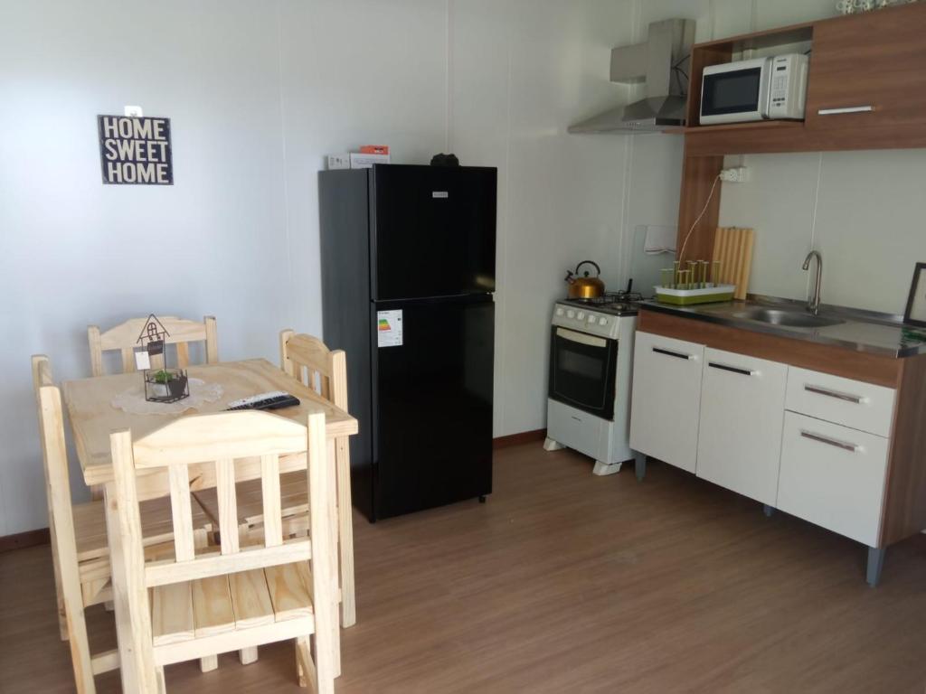 uma cozinha com um frigorífico preto e uma mesa em Nuestro sueño 2 em Colônia do Sacramento