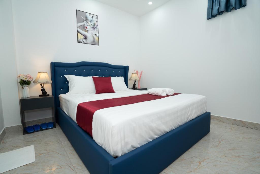 a bedroom with a blue and white bed with red pillows at EROS HOTEL in Ho Chi Minh City