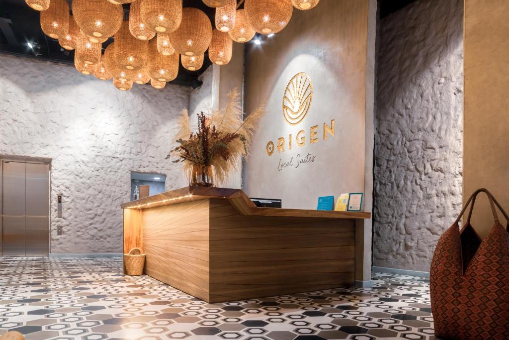 een lobby met een balie en kroonluchters bij Origen Local Suites in Medellín