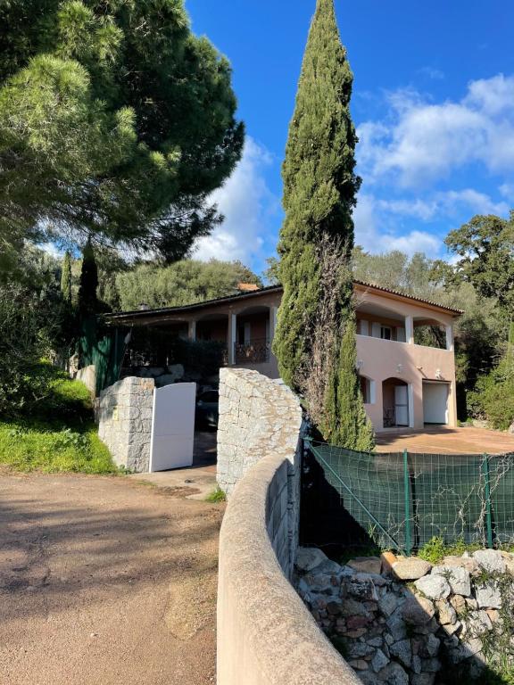une maison avec une clôture et un arbre dans l'établissement Maison Porto vecchio proche belles plages, à Porto-Vecchio