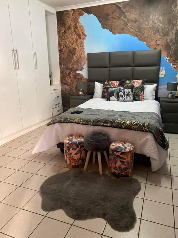 a bedroom with a large bed with a painting on the wall at P&l exclusive beauty parlour in Johannesburg