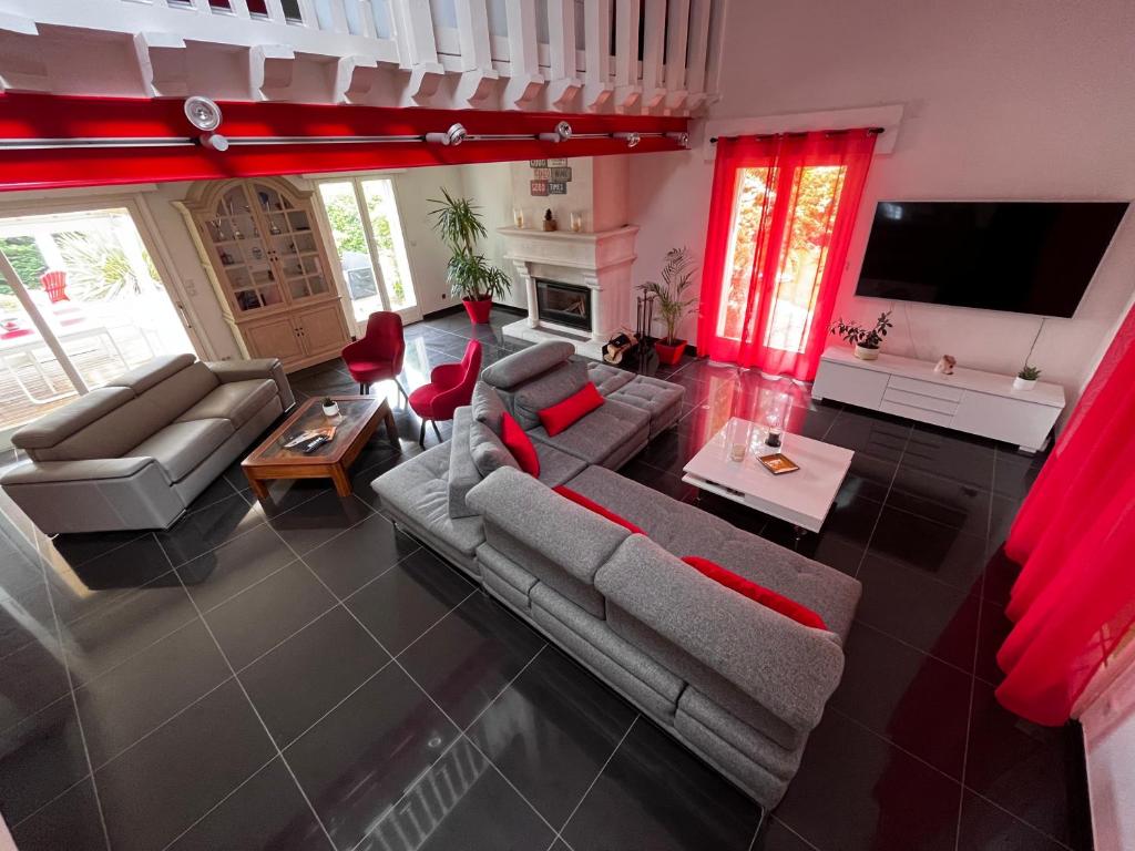 una vista aérea de una sala de estar con cortinas rojas en Villa avec piscine à 10 min du circuit des 24h du Mans en Spay