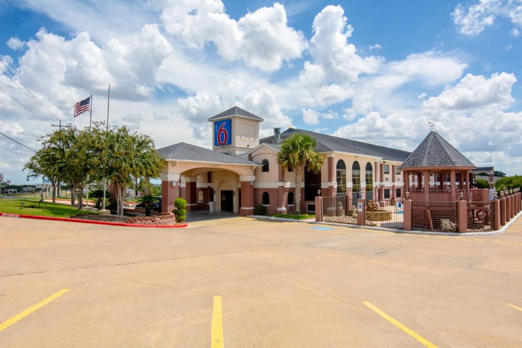 a building with a parking lot in front of it at Studio 6 Suites Brenham, TX in Brenham