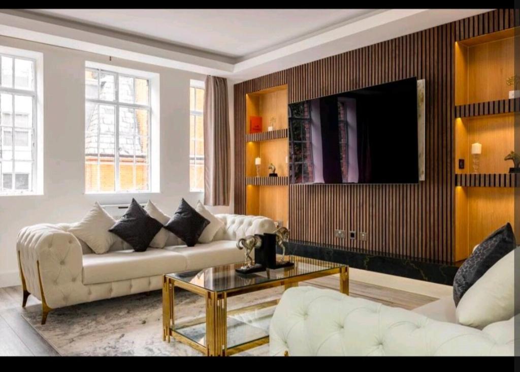 a living room with two couches and a tv at Luxury 4 Bed Knights Bridge in London