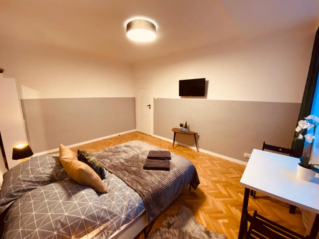 sypialnia z łóżkiem i telewizorem na ścianie w obiekcie ClickTheFlat Karmelicka Apart Rooms w Warszawie