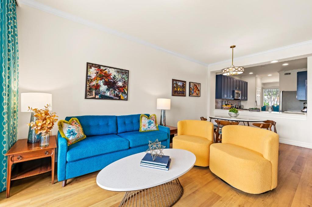 a living room with a blue couch and two chairs at Catina Golf Condo at the Lely Resort in Naples