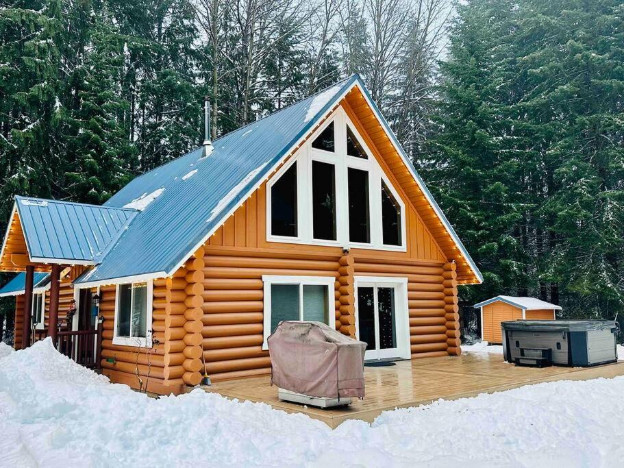 a cabin with a blue roof in the snow at Hawthorn Cabin in Pine Glen