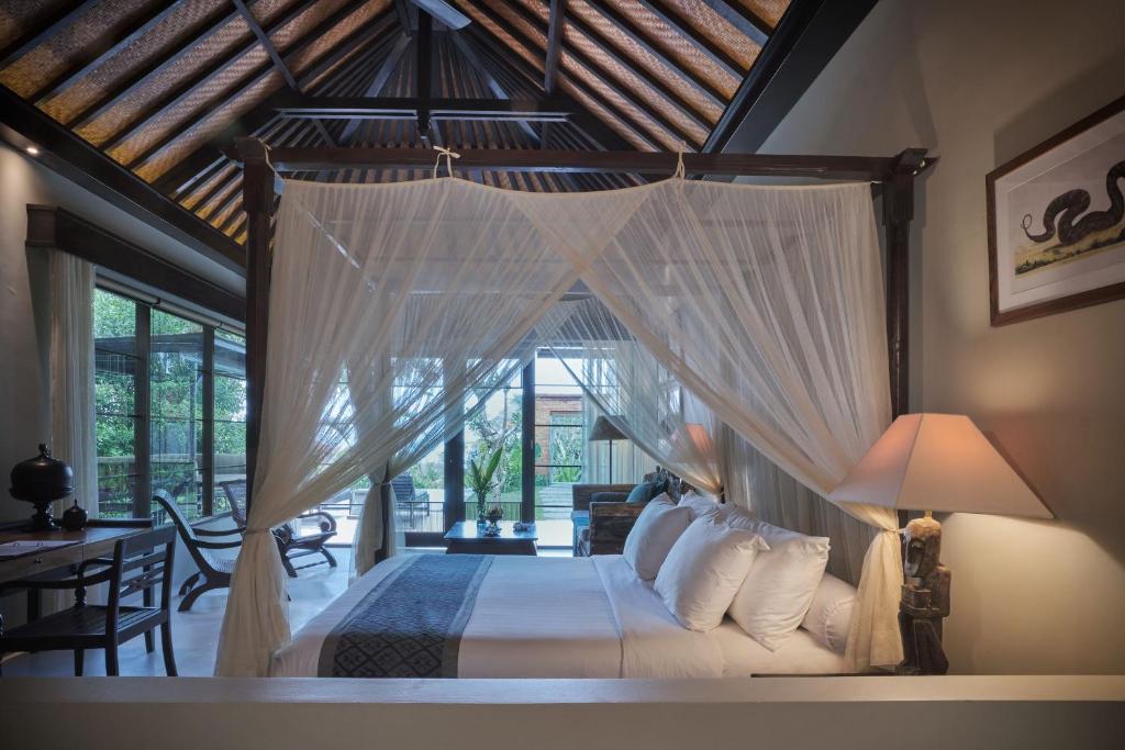 a bedroom with a bed with a canopy at The Damai in Lovina