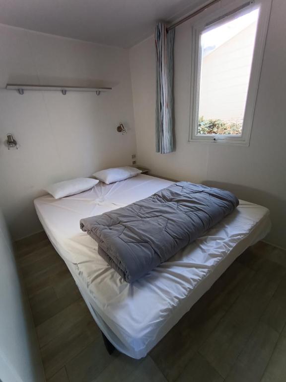 a bedroom with two beds and a window at camping 4 étoiles SIBLU Les sables du midi in Valras-Plage